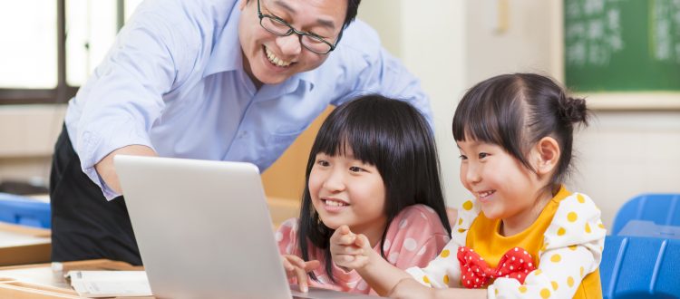 Man and two kids smiling looking at a computer screen